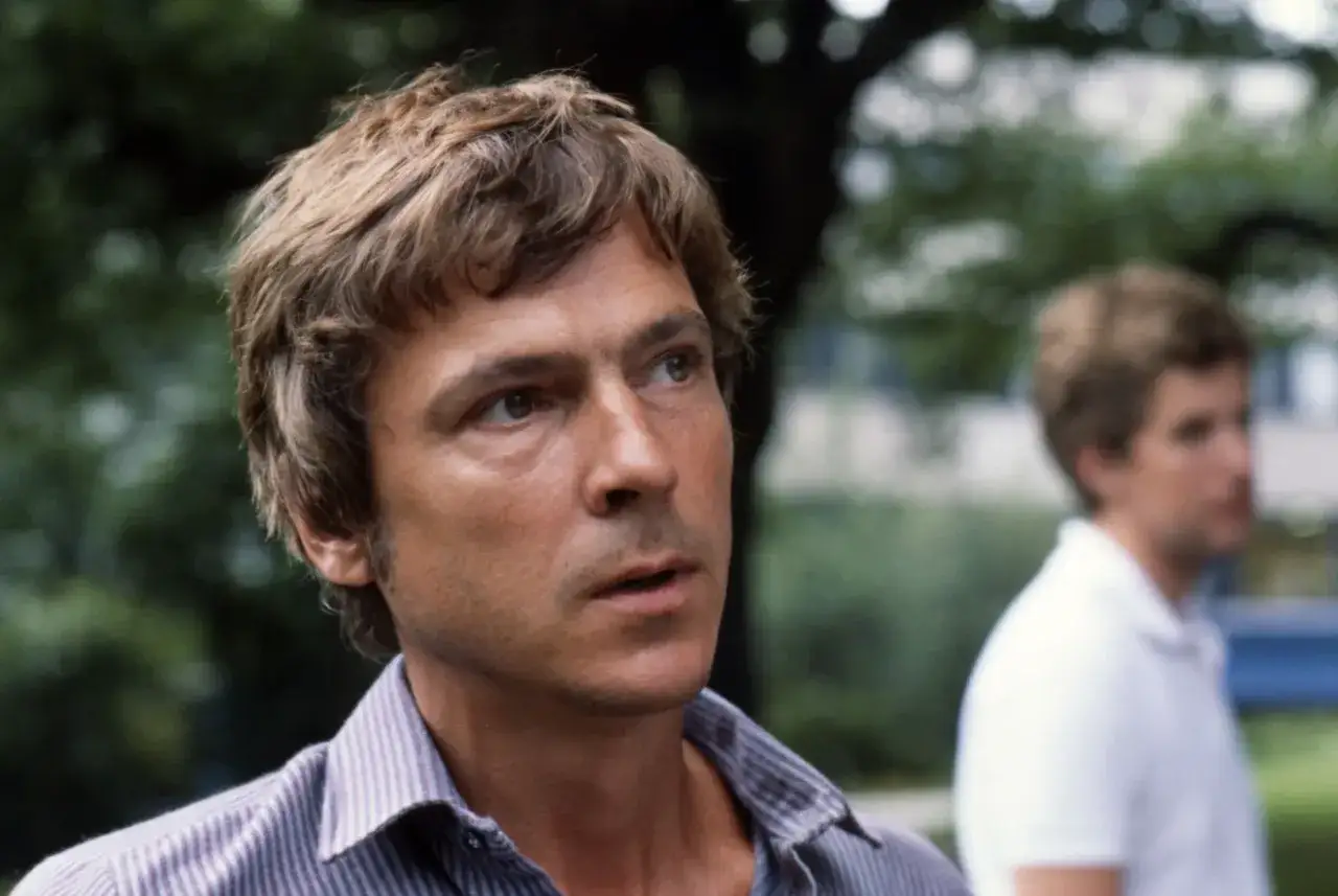 Carl Ivar Nilsson, en man med brunt, rufsigt hår, tittar bort. I bakgrunden skymtar en annan man.