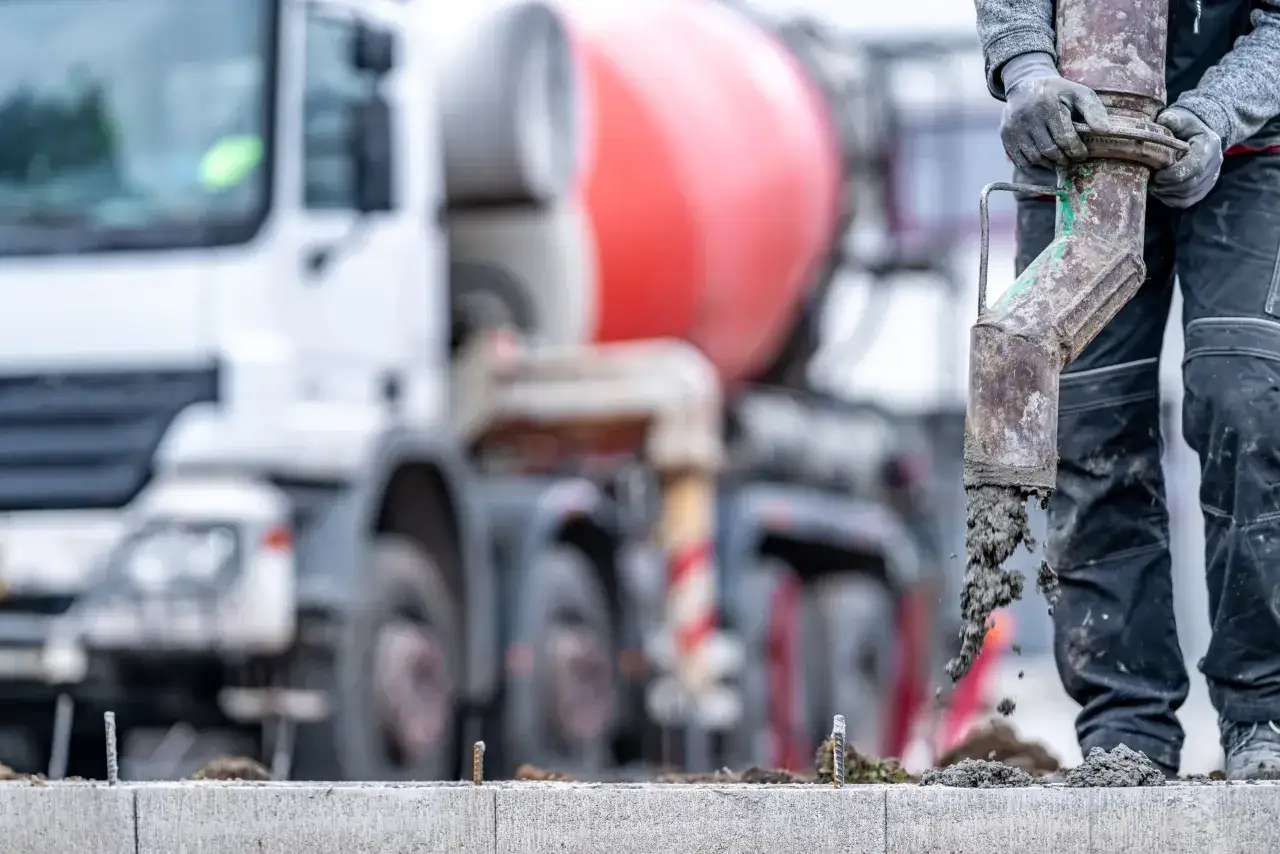 Robotnik wylewa beton B25 z pompy. Sprawdź aktualną beton b25 cena za m3.