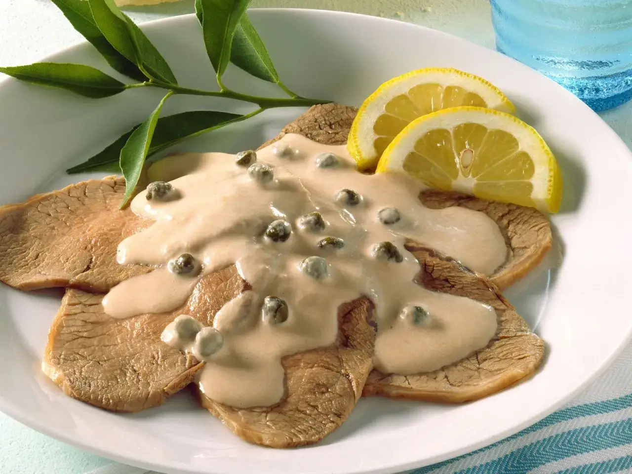 Vitello Tonnato: zarte Kalbfleischscheiben mit cremiger Thunfischsauce und Kapern, garniert mit Zitronenspalten. Das beste Vitello Tonnato Rezept!
