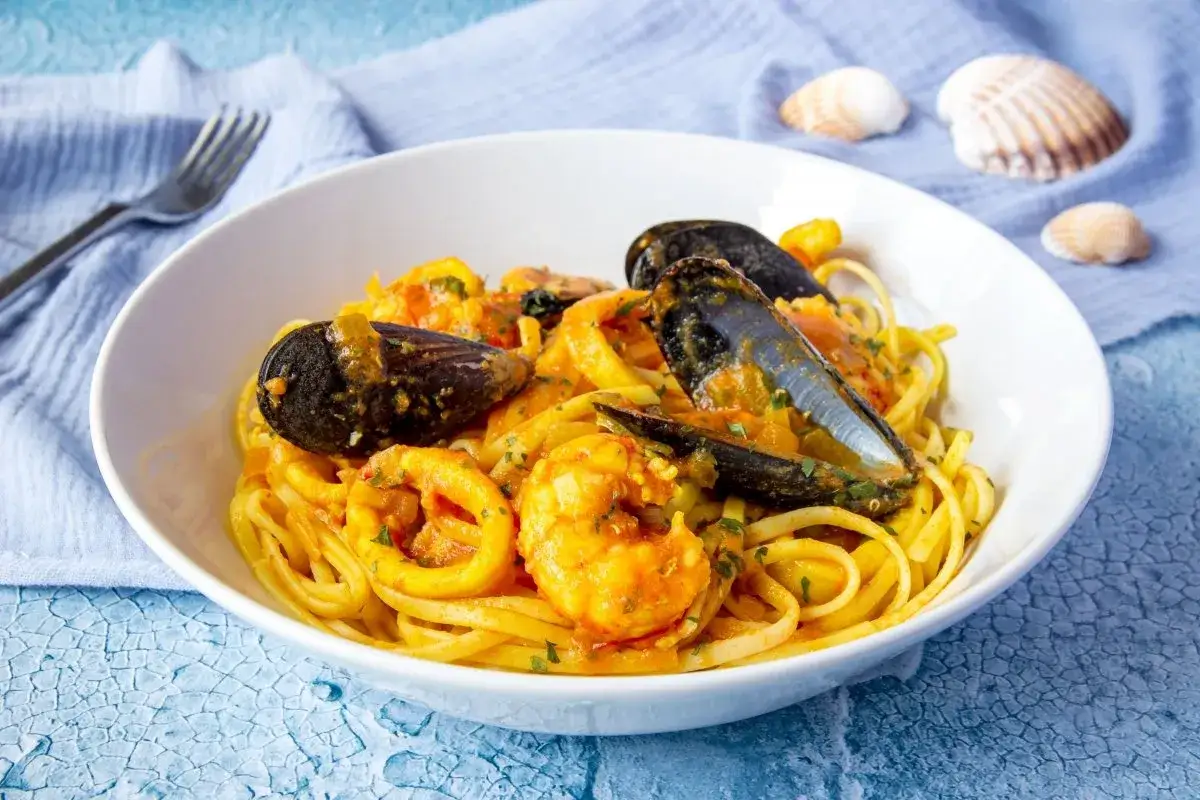 Delicioso plato de espaguetis a la marinera con mejillones, gambas y calamares en una rica salsa.