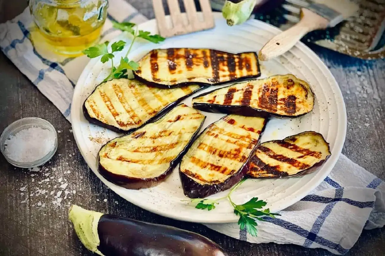 Gegrillte Auberginenscheiben mit Schale, garniert mit Petersilie. Perfekt zum **Aubergine mit Schale essen**.