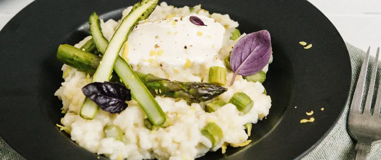 Un crémeux risotto aux asperges facile et rapide, garni de fromage frais et de basilic pourpre.