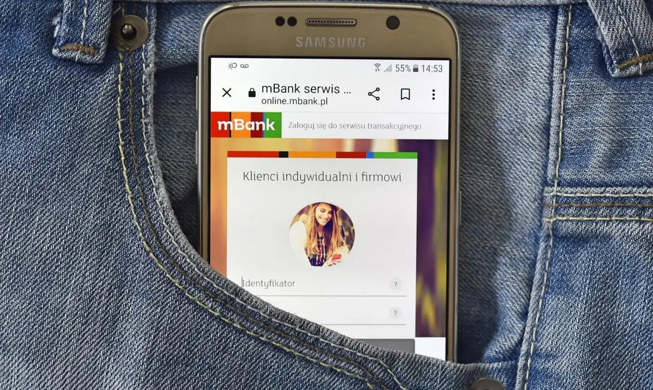 Telefon w kieszeni dżinsów wyświetla stronę logowania do mBanku. Chcesz wiedzieć, jak anulować zlecenie stałe mBank? Zaloguj się do serwisu transakcyjnego.