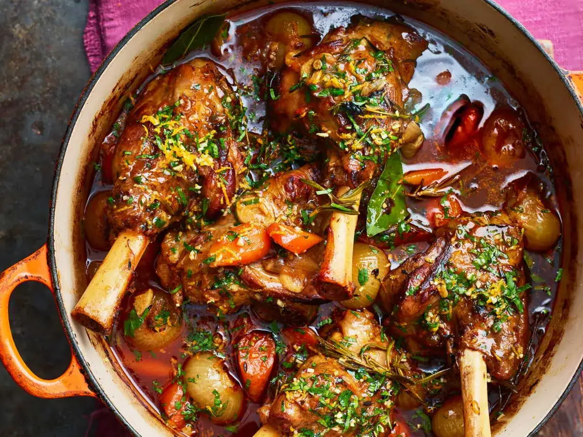 Pintade en cocotte mijotant dans un jus savoureux avec des oignons, des carottes et des herbes. Un plat réconfortant et parfumé.