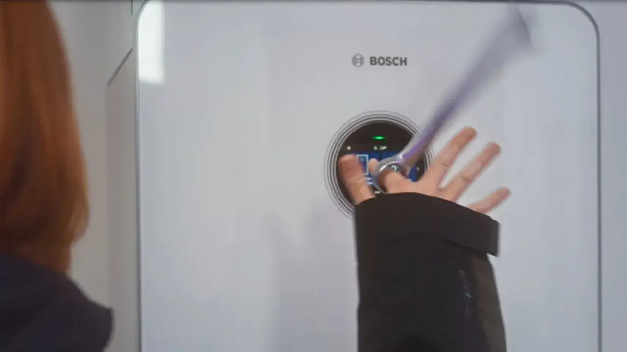 En hand interagerar med displayen på en Bosch Compress 7800i värmepump.