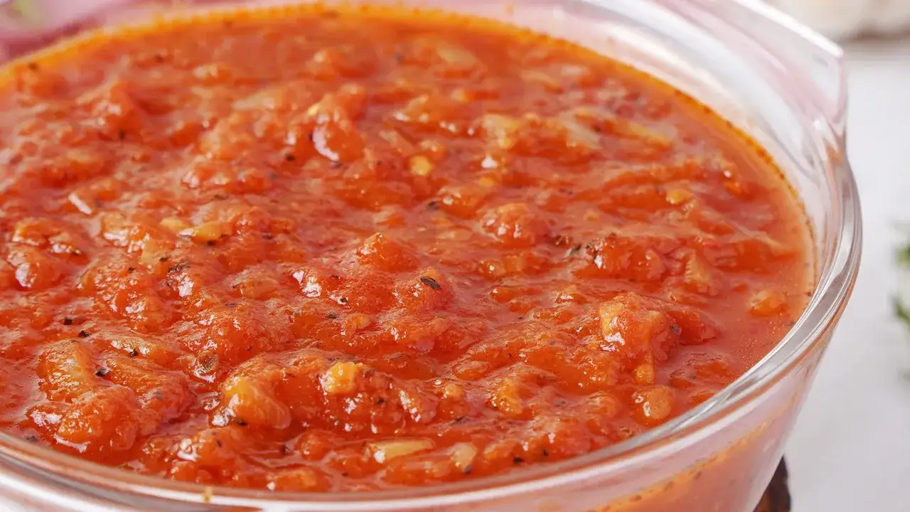Frische, hausgemachte Tomatensauce in einer Glasschüssel. Perfekt zum Tomatensauce selber machen, mit sichtbaren Tomatenstückchen und Kräutern.