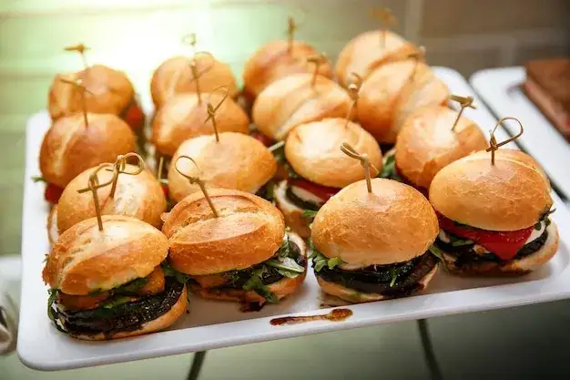 assortiment de mini burgers variés sur un plateau apéritif en ardoise