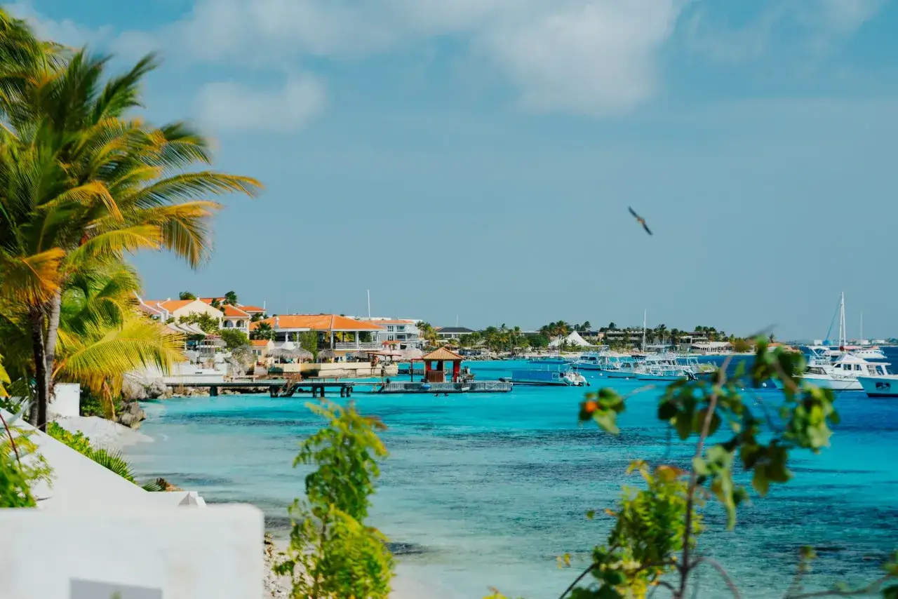 Rajska plaża na Bonaire, z palmami, turkusową wodą i łodziami. Idealne miejsce na wakacje.