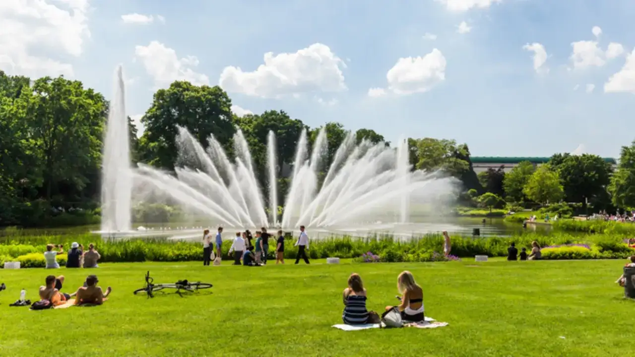 Menschen genie&szlig;en die beeindruckenden Wasserspiele Hamburg an einem sonnigen Tag im Park.
