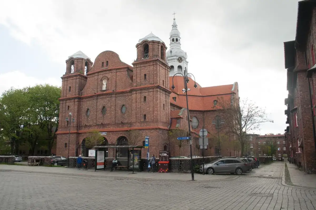 Spacer po Nikiszowcu: imponująca ceglana bazylika z wieżą zegarową i charakterystyczne familoki.