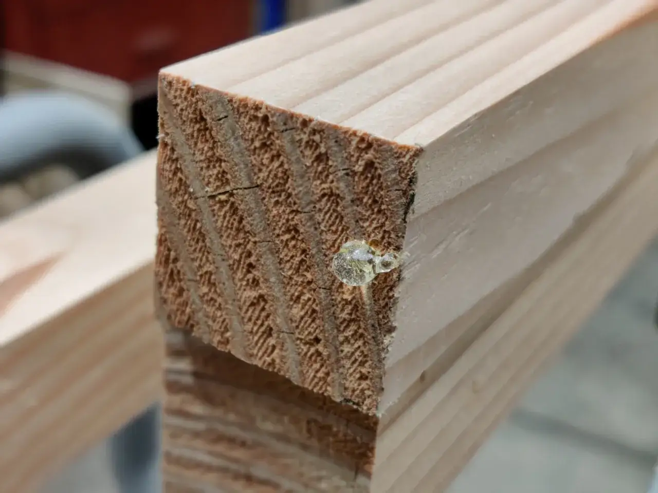 Kleine Harzblase auf einem Holzstück. Um das Harz von Holz zu entfernen, braucht man Geduld.