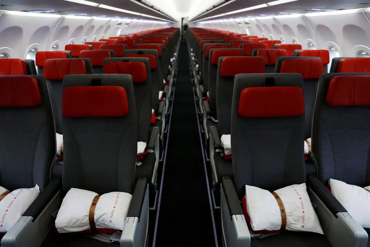 Puste siedzenia w samolocie A321XLR, gotowe na podróż. Czekają poduszki z napisem