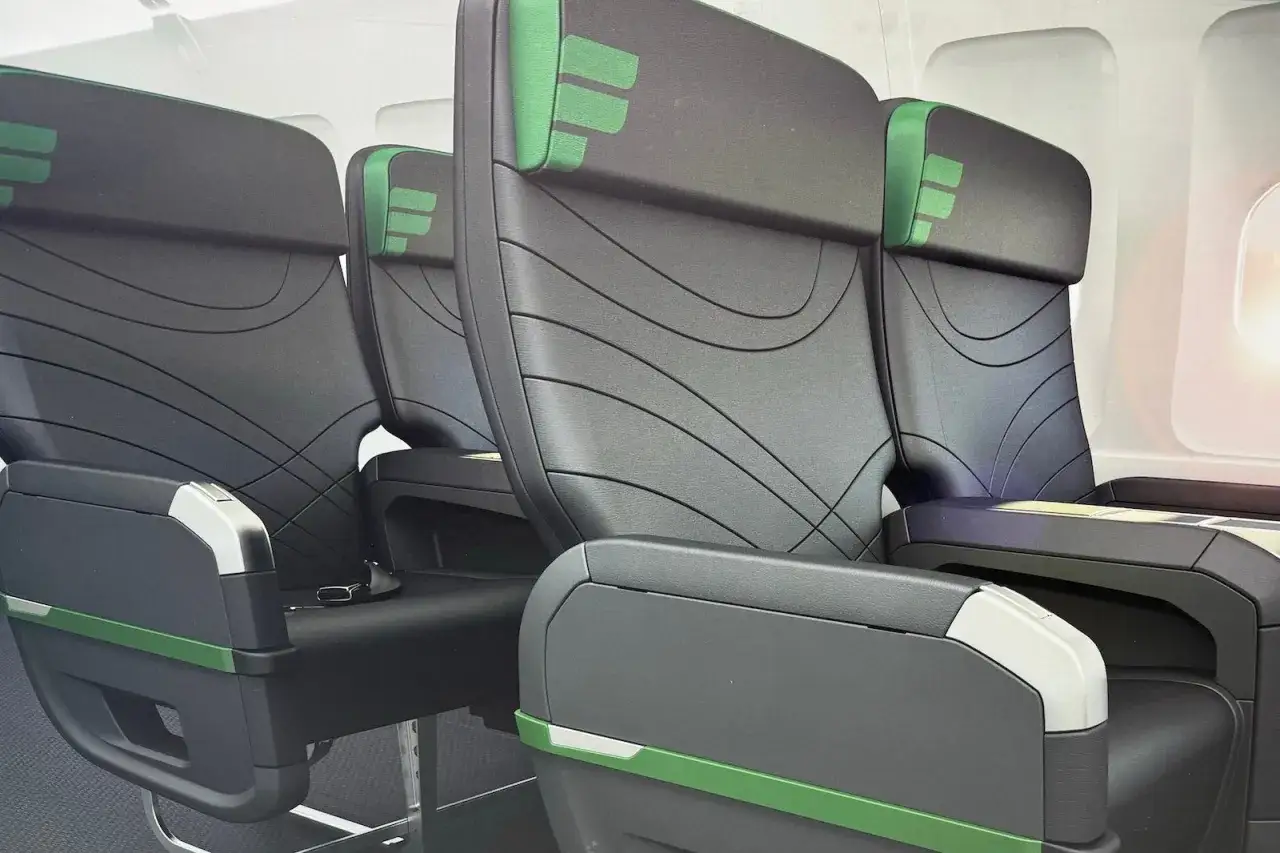 Rows of black airplane seats with green accents. Does Frontier have first class? These seats look comfortable, but it's unclear if they are.