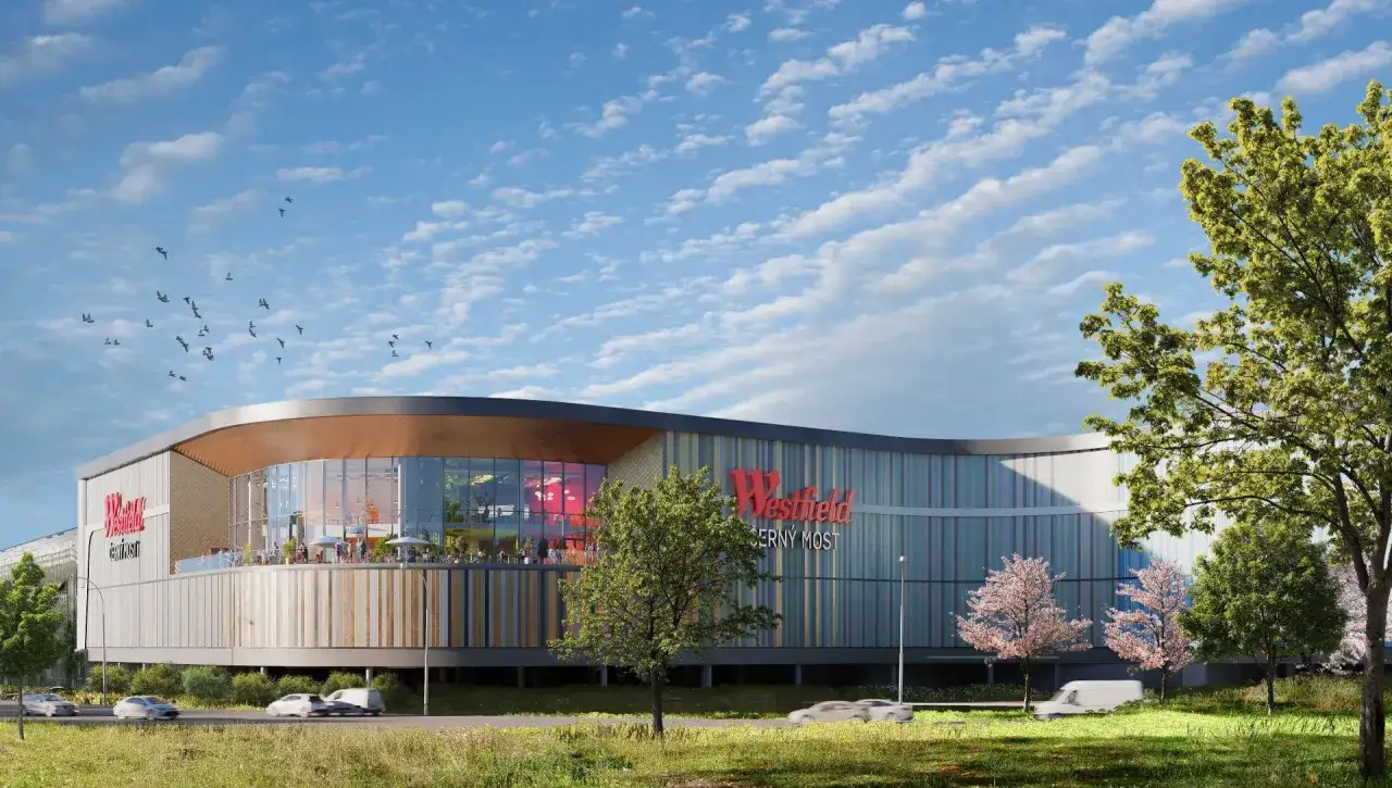 Nowoczesne centrum handlowe Westfield Černý Most z kolorową fasadą i tarasem, otoczone zielenią.