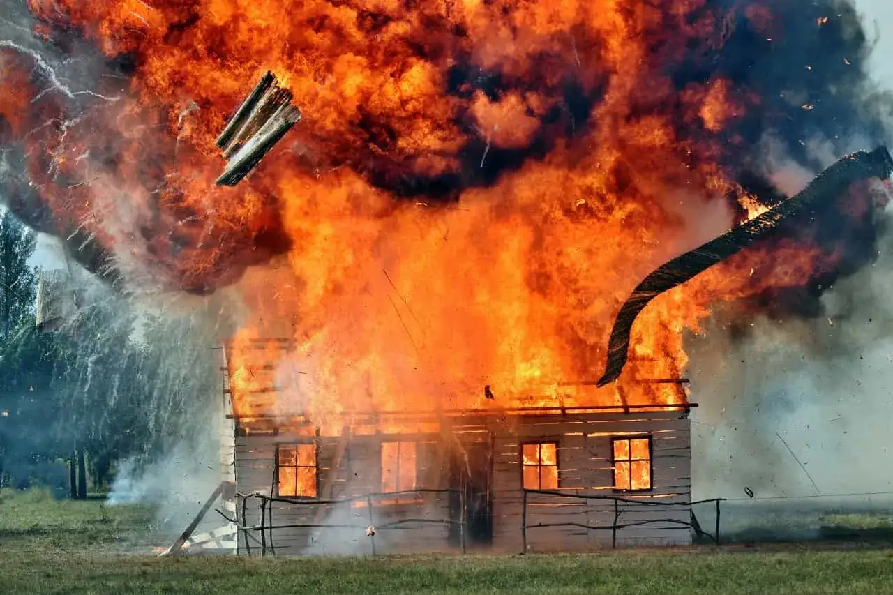 Dom w płomieniach, eksplozja i unoszące się w powietrzu fragmenty drewna. To efekt podpalenia, które pochłonęło budynek.