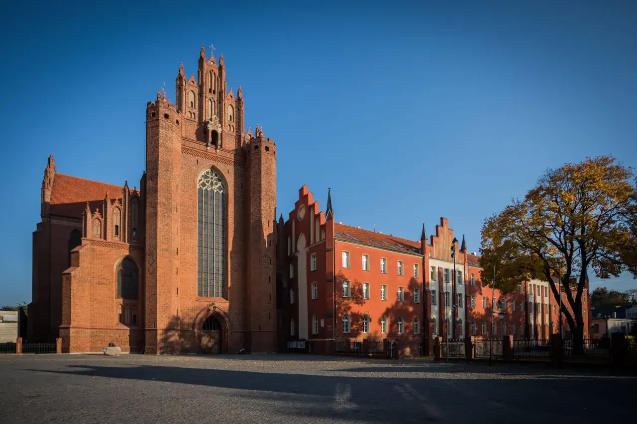 Gotycka katedra i kolorowe kamienice w Pelplinie to jedne z gł&oacute;wnych atrakcji miasta. Jesienne liście drzew dodają uroku.