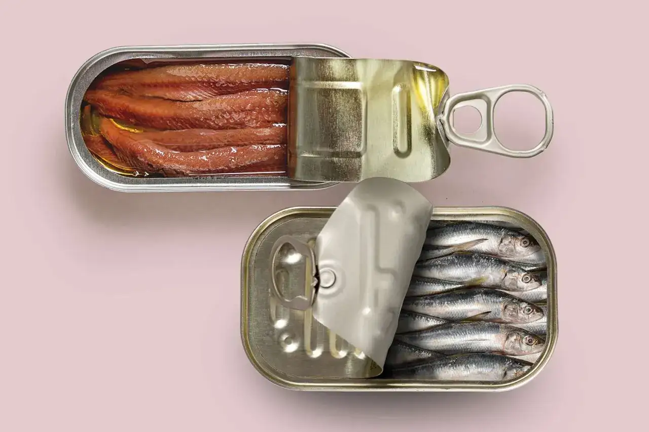Otwarta puszka sardynek i druga z anchois. Co to są anchois? Małe, słone rybki w oleju.