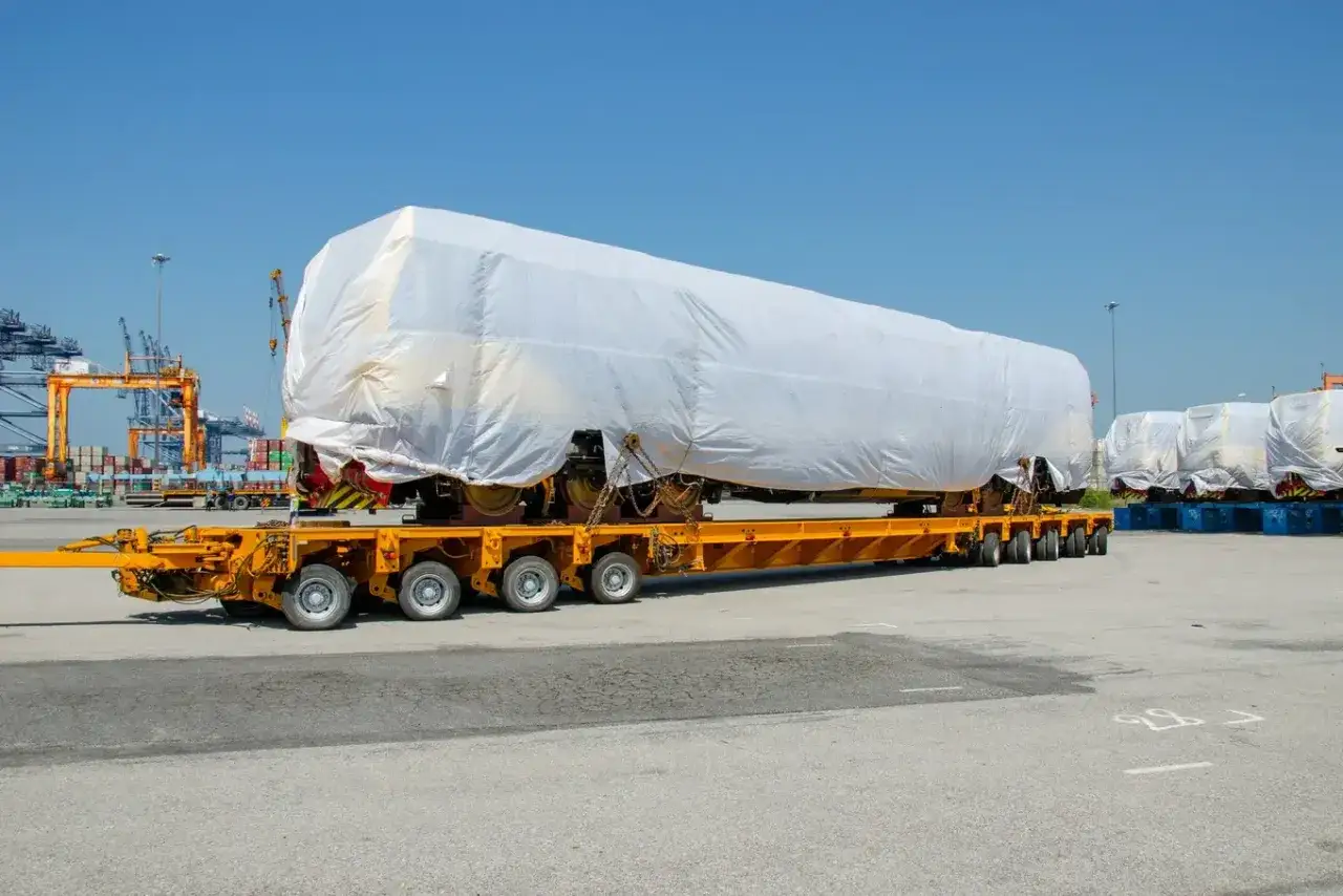 Ciężki ładunek, prawdopodobnie część pociągu, zabezpieczony do transportu zgodnie z warunkami **CPT Incoterms**.