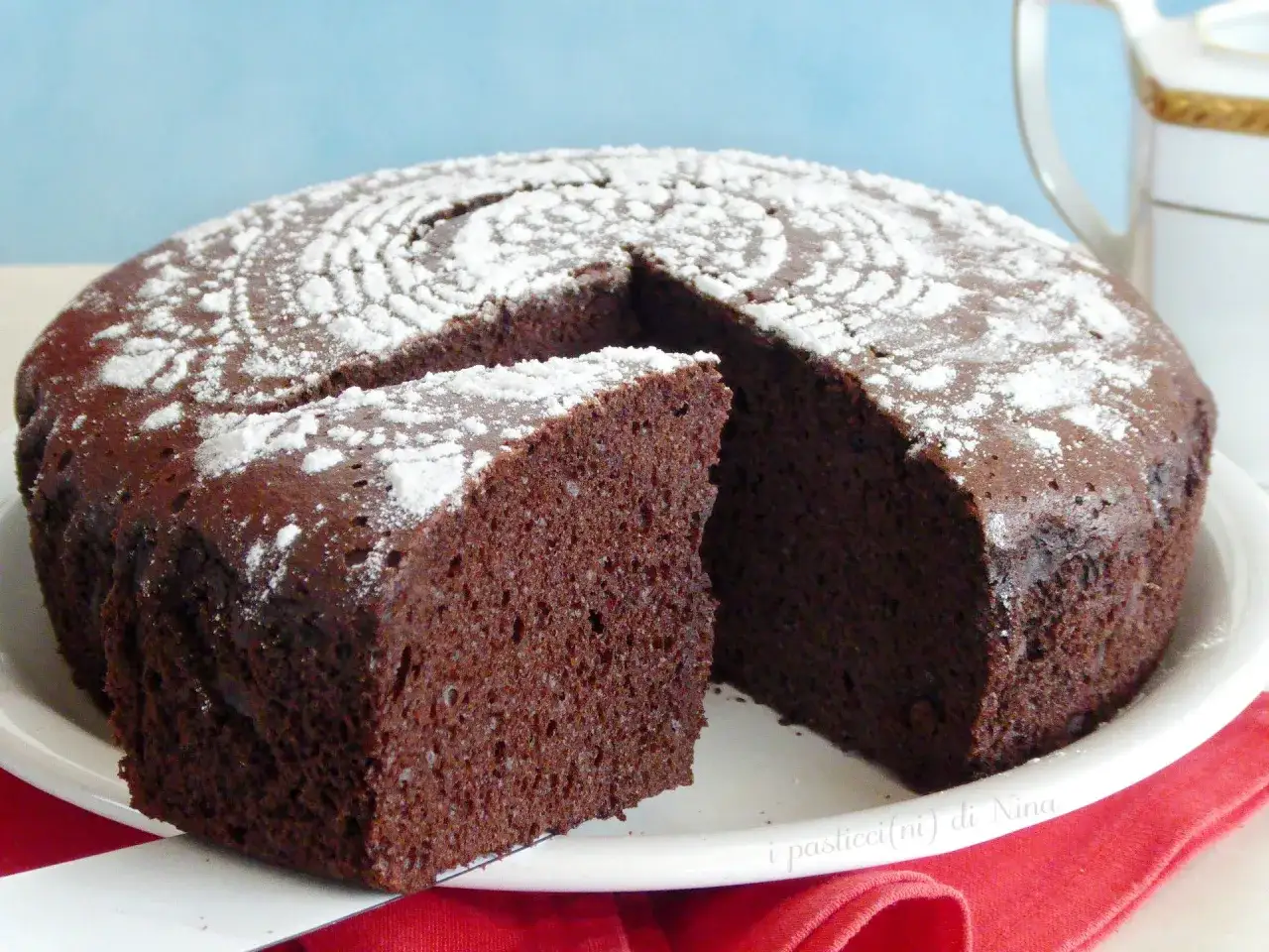 Torta all'acqua al cacao soffice e profumata, spolverata di zucchero a velo, pronta per essere gustata.