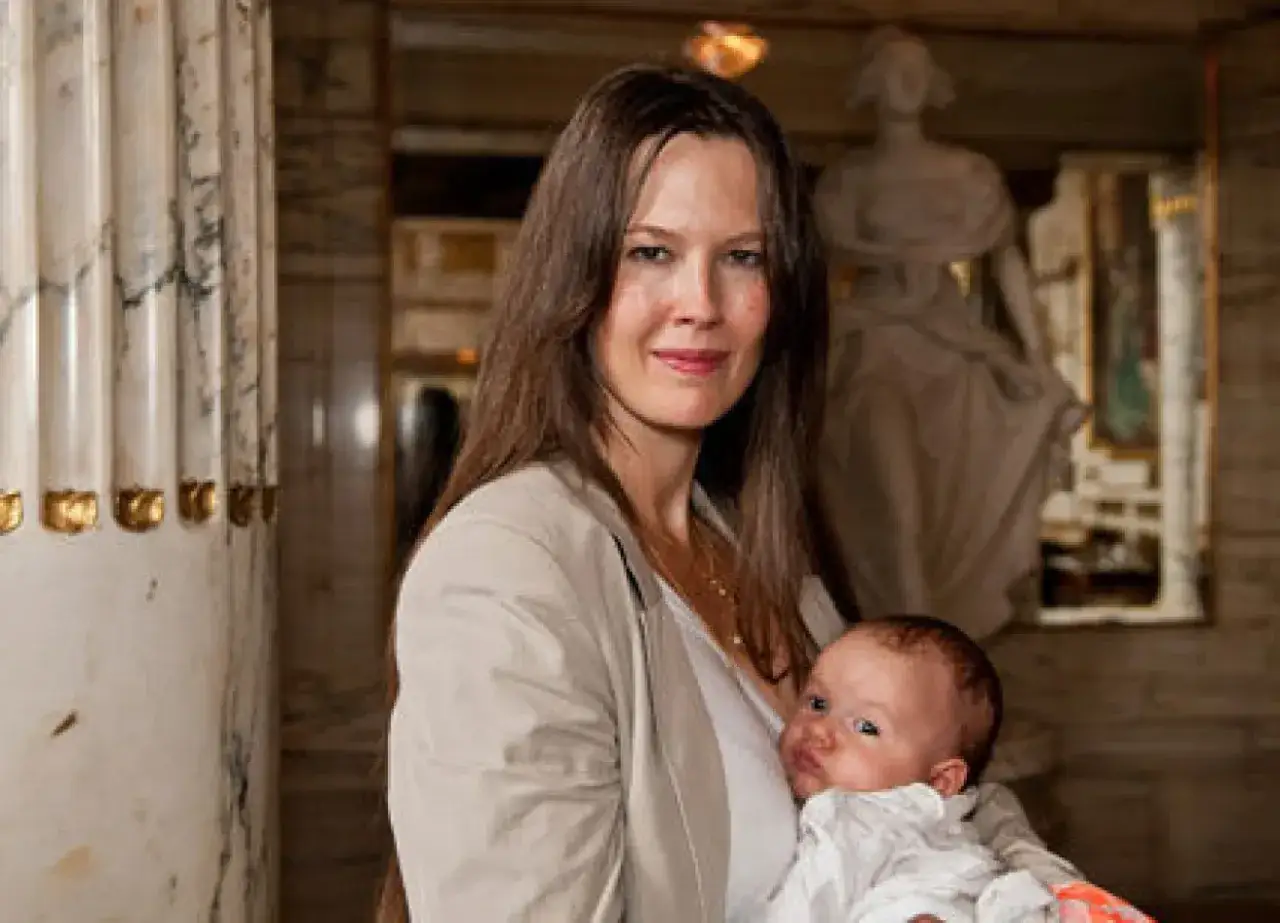 Elin Klinga med sitt barn. En vacker mamma håller sitt spädbarn i famnen.