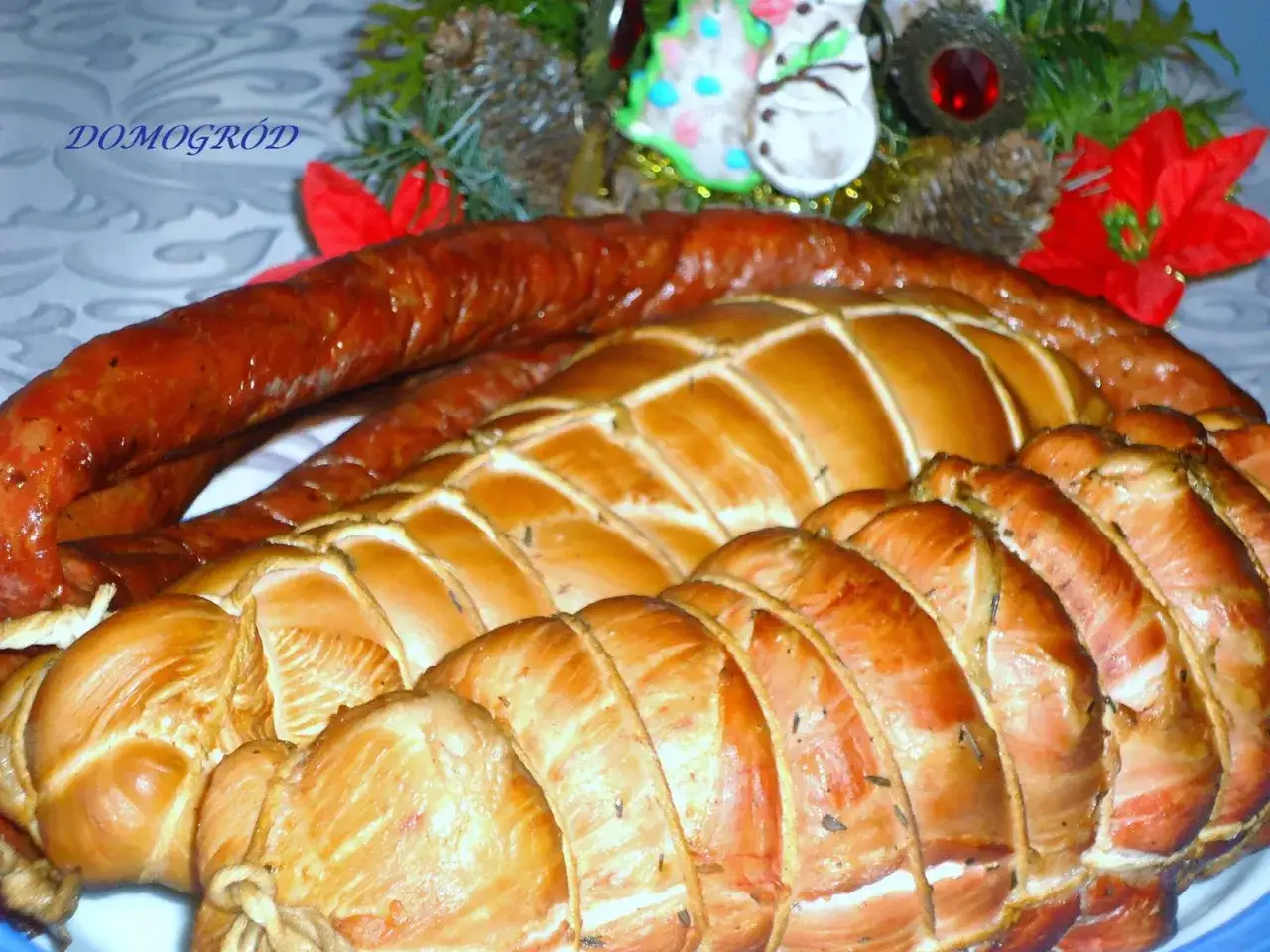Wędliny, w tym kiełbasa i pieczone mięso, przygotowane z użyciem soli peklowej, na tle świątecznych dekoracji.
