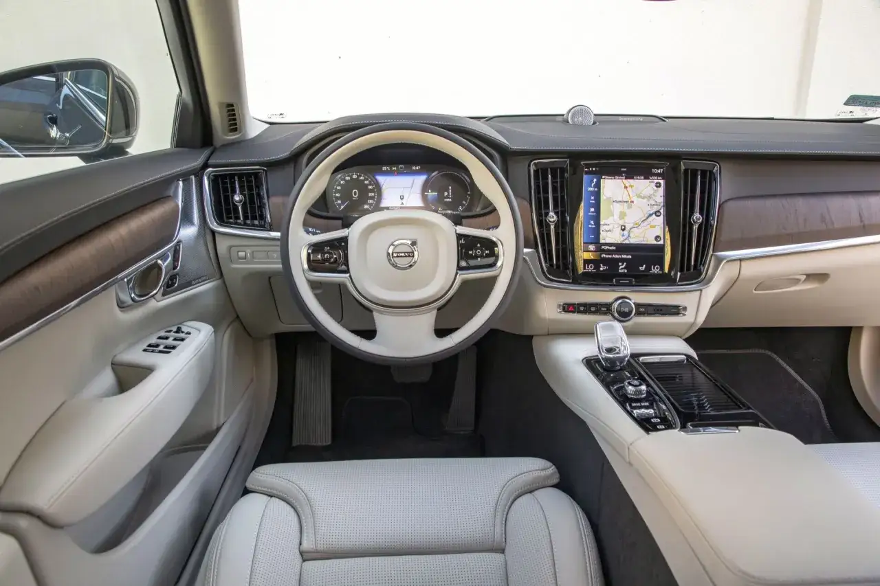 Wnętrze Volvo S90: jasna skóra, drewniane wstawki, duży ekran. Wady? Może brak fizycznych przycisków klimatyzacji.