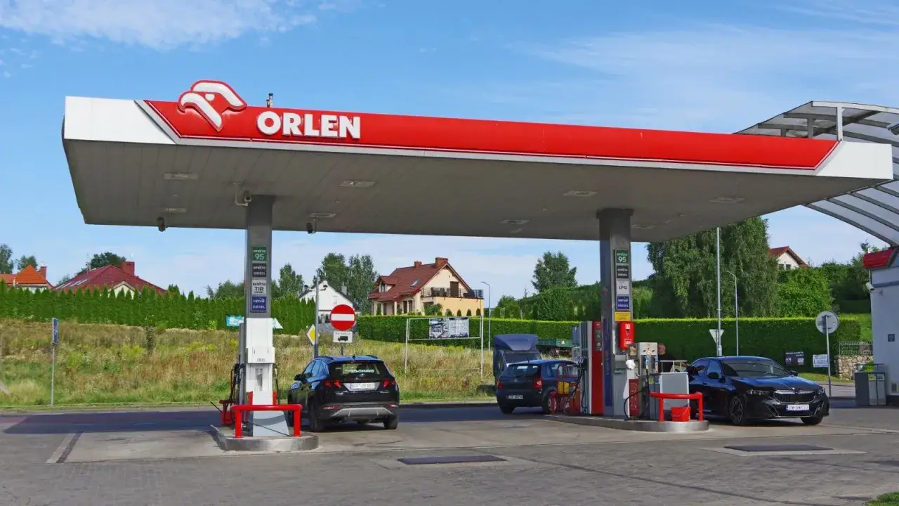 Stacja Orlen z samochodami pod zadaszeniem. Zastanawiasz się, ile zarabia się na stacji benzynowej?