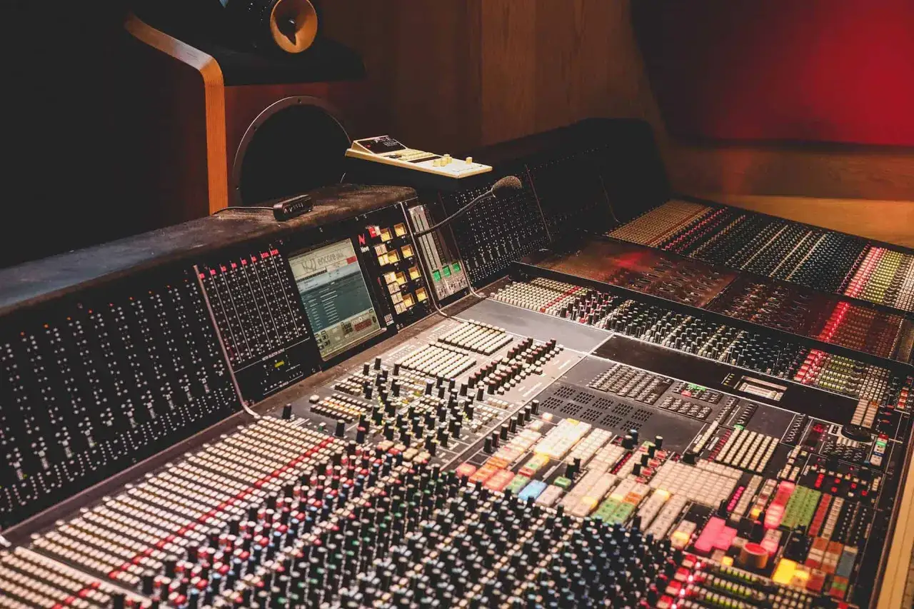 Ein Mischpult, das die Wahl zwischen digitaler und analoger Klangbearbeitung symbolisiert. Viele Regler und Schalter für kreative Soundgestaltung.