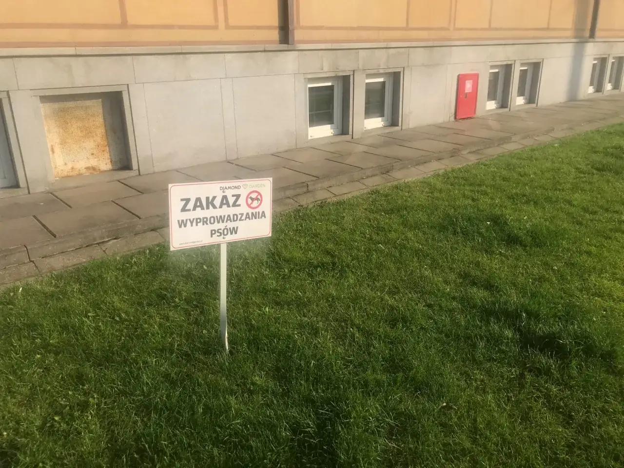Tabliczka informuje o zakazie wyprowadzania psów na terenie wspólnoty.