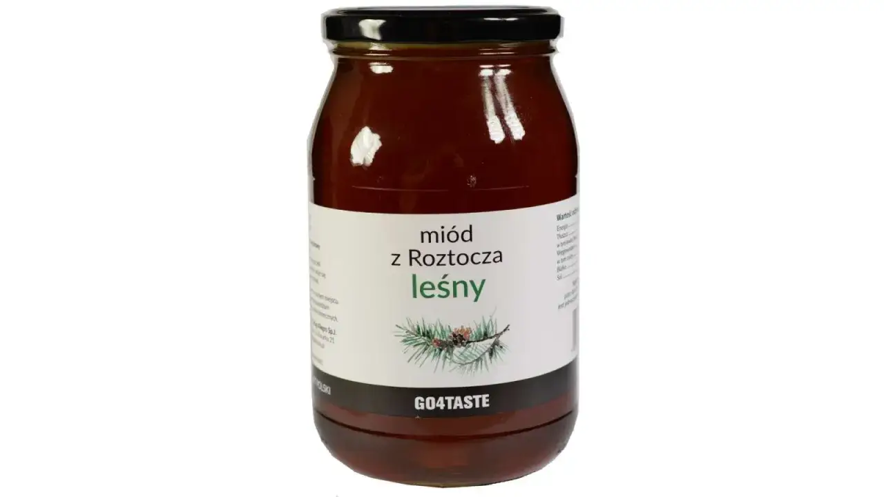 Słoik miodu leśnego z Roztocza. Etykieta podpowiada, jak rozpoznać prawdziwy mi&oacute;d, prezentując gałązkę sosny.