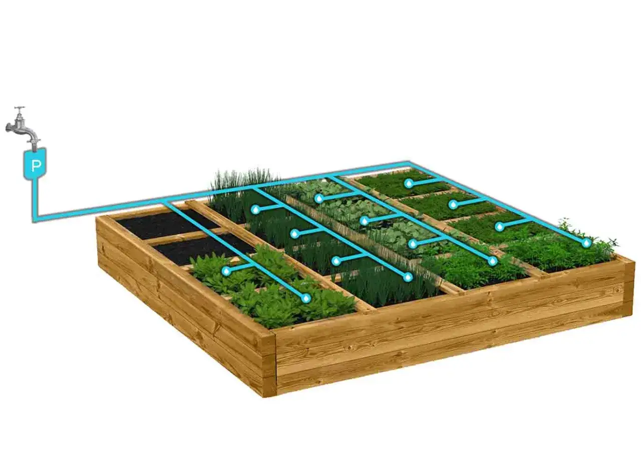 Sistema di irrigazione fai da te per un orto rialzato, con tubi blu che distribuiscono acqua alle diverse colture.