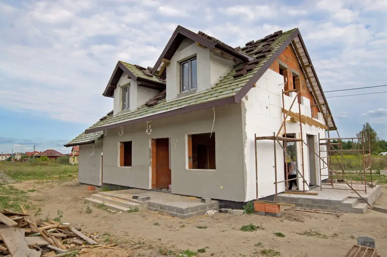 Budowa domu w trakcie, z widocznymi elementami konstrukcyjnymi i rusztowaniami. Idealne miejsce na realizację marzeń o domach na raty bez banku.