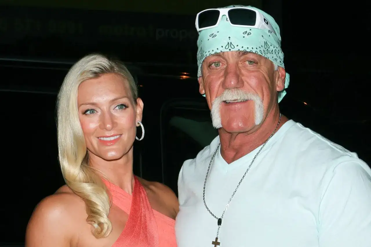 Hulk Hogan w swojej charakterystycznej strefie, obok kobiety w pomarańczowej sukience.