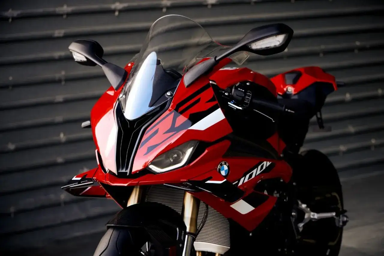 Czerwony motocykl sportowy BMW S1000RR z 2015 roku, z czarnymi akcentami i logo BMW.