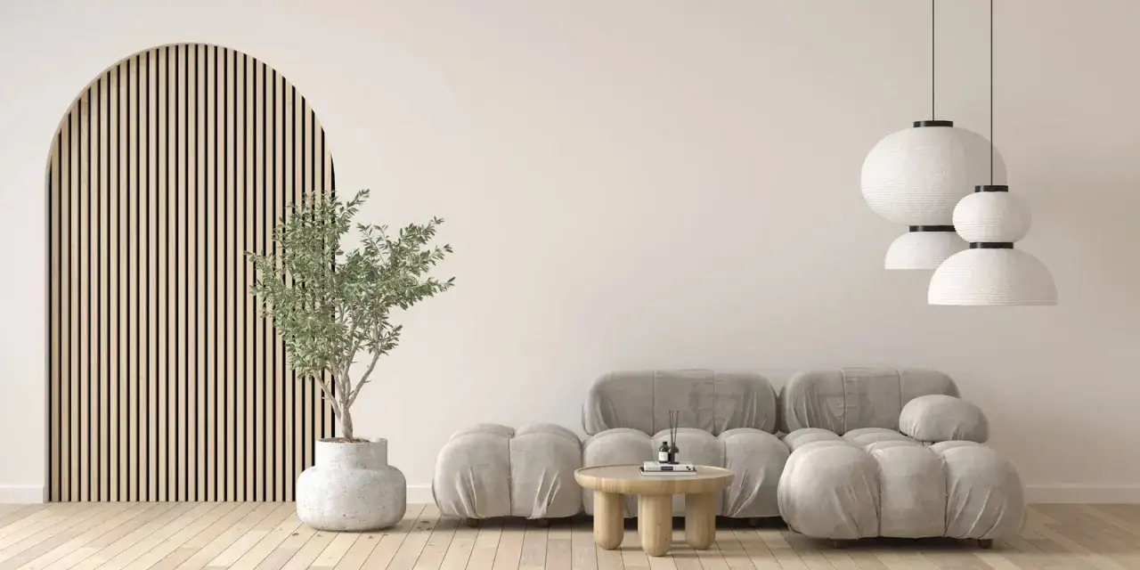 Salon w stylu japandi: łuk z drewnianych listewek, szara sofa, okrągły stolik i wiszące lampy.