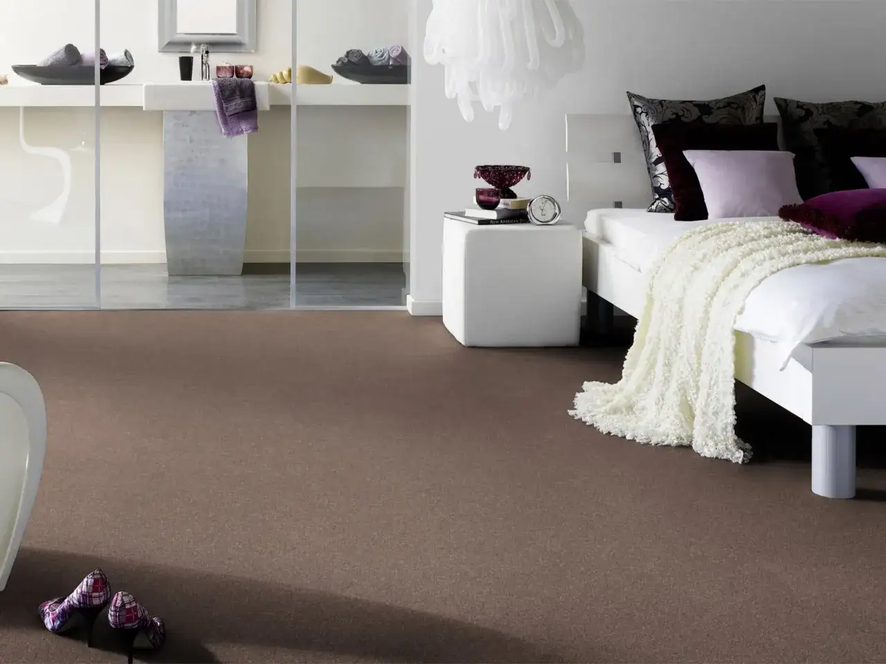 Ein gemütlicher **Teppich** bedeckt das **ganze Zimmer**, von der modernen Badewanne bis zum eleganten Bett mit vielen Kissen.