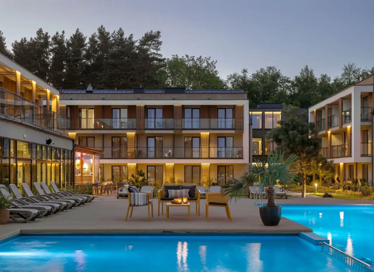 Nowoczesny hotel z basenem i leżakami, otoczony lasem. Idealne miejsce na relaks i odkrywanie atrakcji Grzybowa.