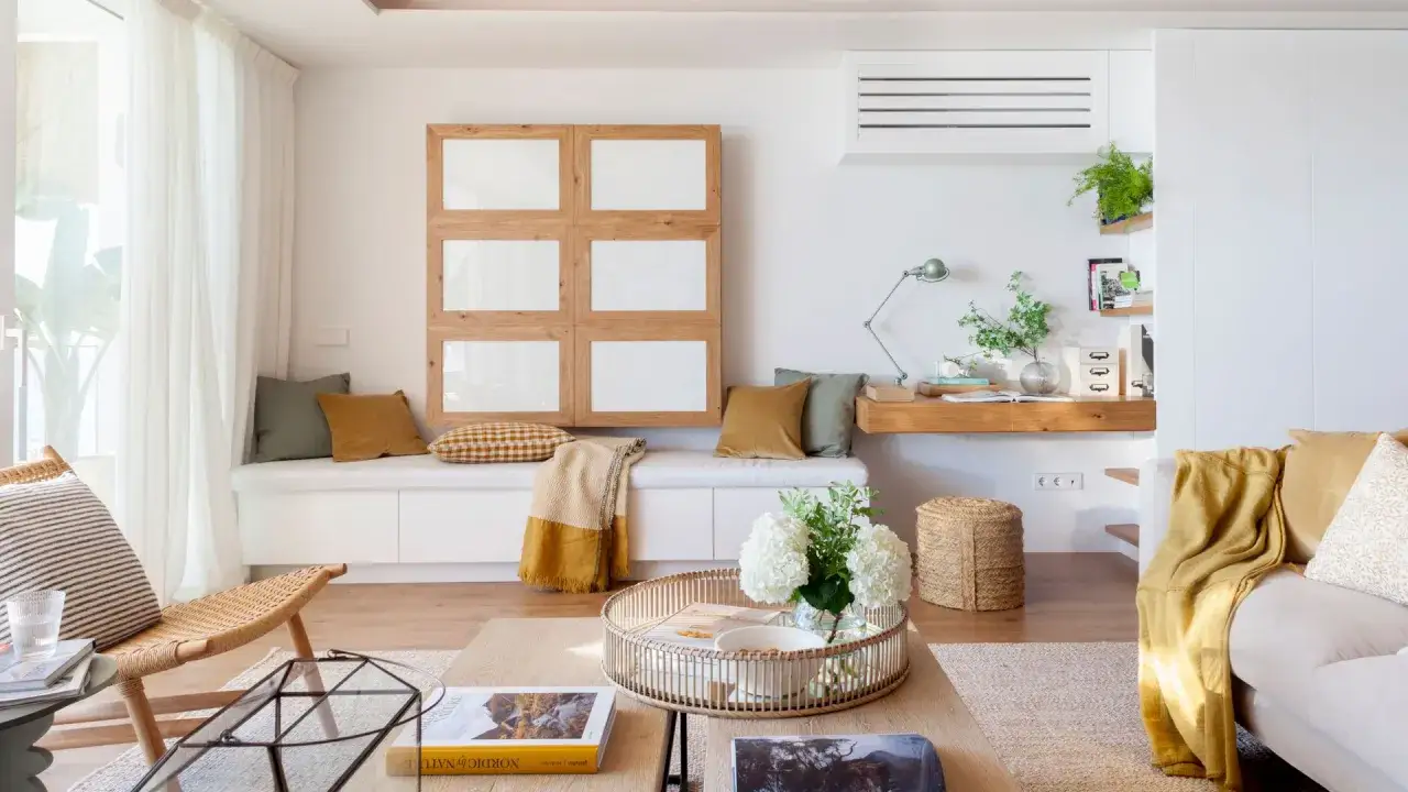 Acogedora zona chill out interior con banco, sillón de mimbre y sofá. Tonos cálidos y naturales invitan al relax.