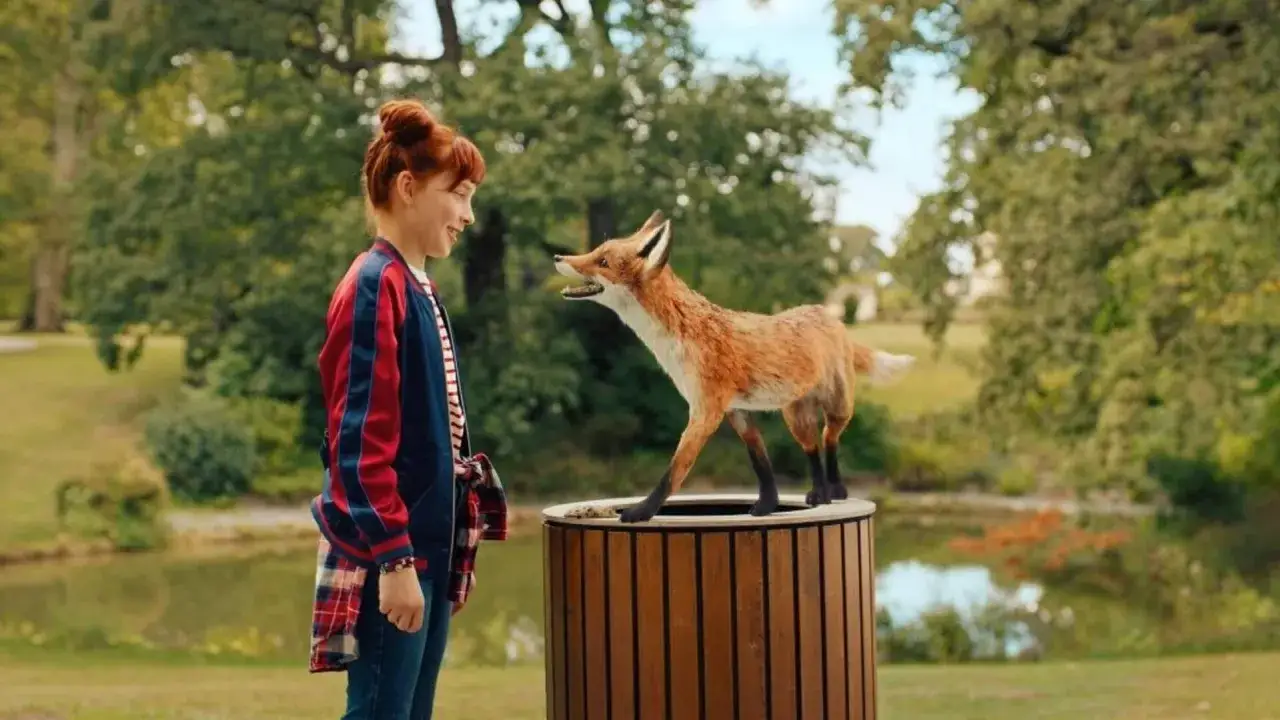Ida und Rabbat, ein Fuchs, treffen sich im Park. Rabbat steht auf einem Holzbehälter und schaut Ida an.