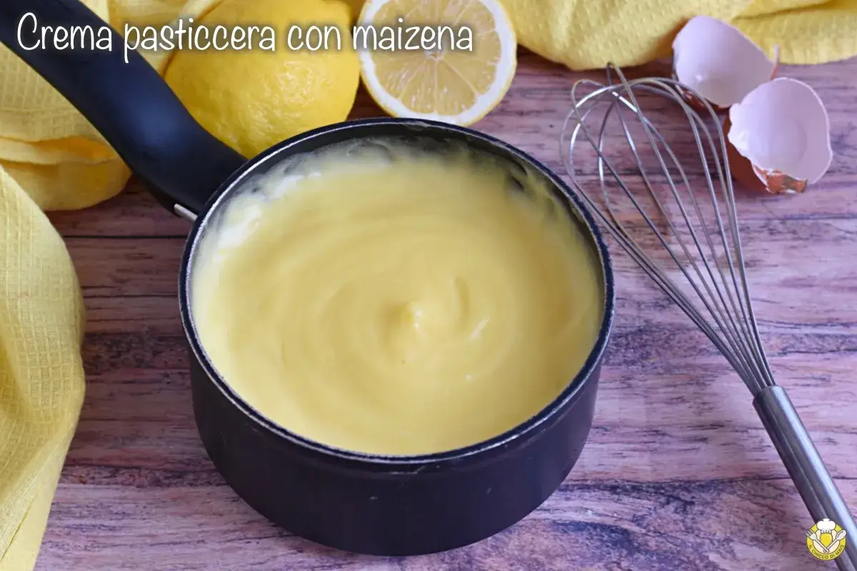 Crema pasticcera con amido di mais, liscia e vellutata, pronta per farcire dolci. Accanto, limoni, frusta e gusci d'uovo.