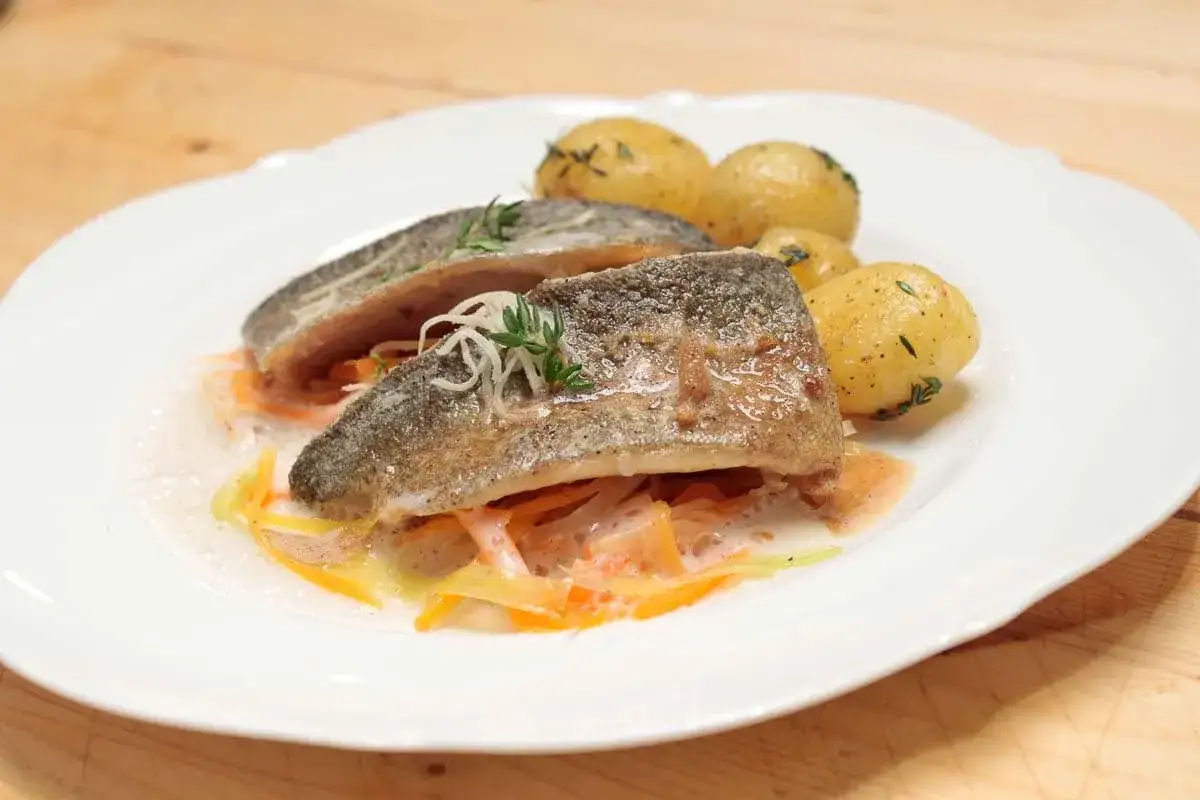 Zartes Forellenfilet braten mit kleinen Kartoffeln und Gemüsestreifen in einer cremigen Sauce. Ein Genuss!