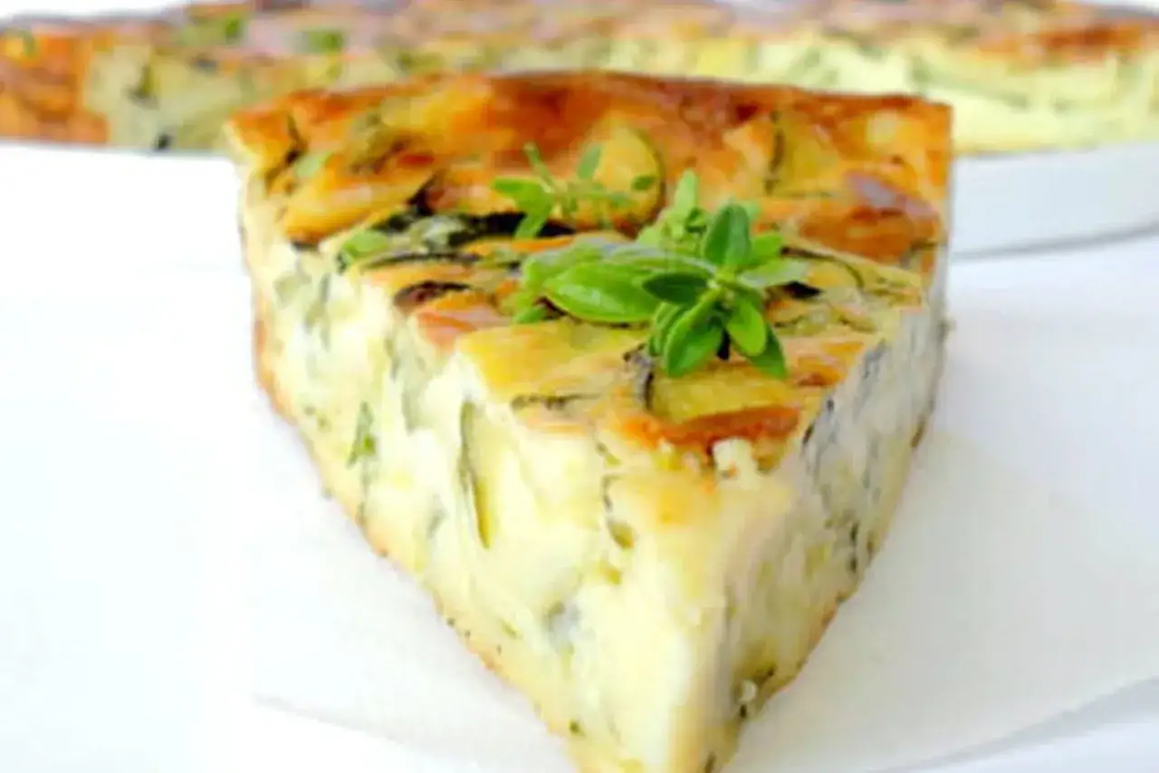 Tranche de clafoutis aux courgettes, garnie de quelques brins de thym frais. Un d&eacute;lice savoureux et l&eacute;ger.