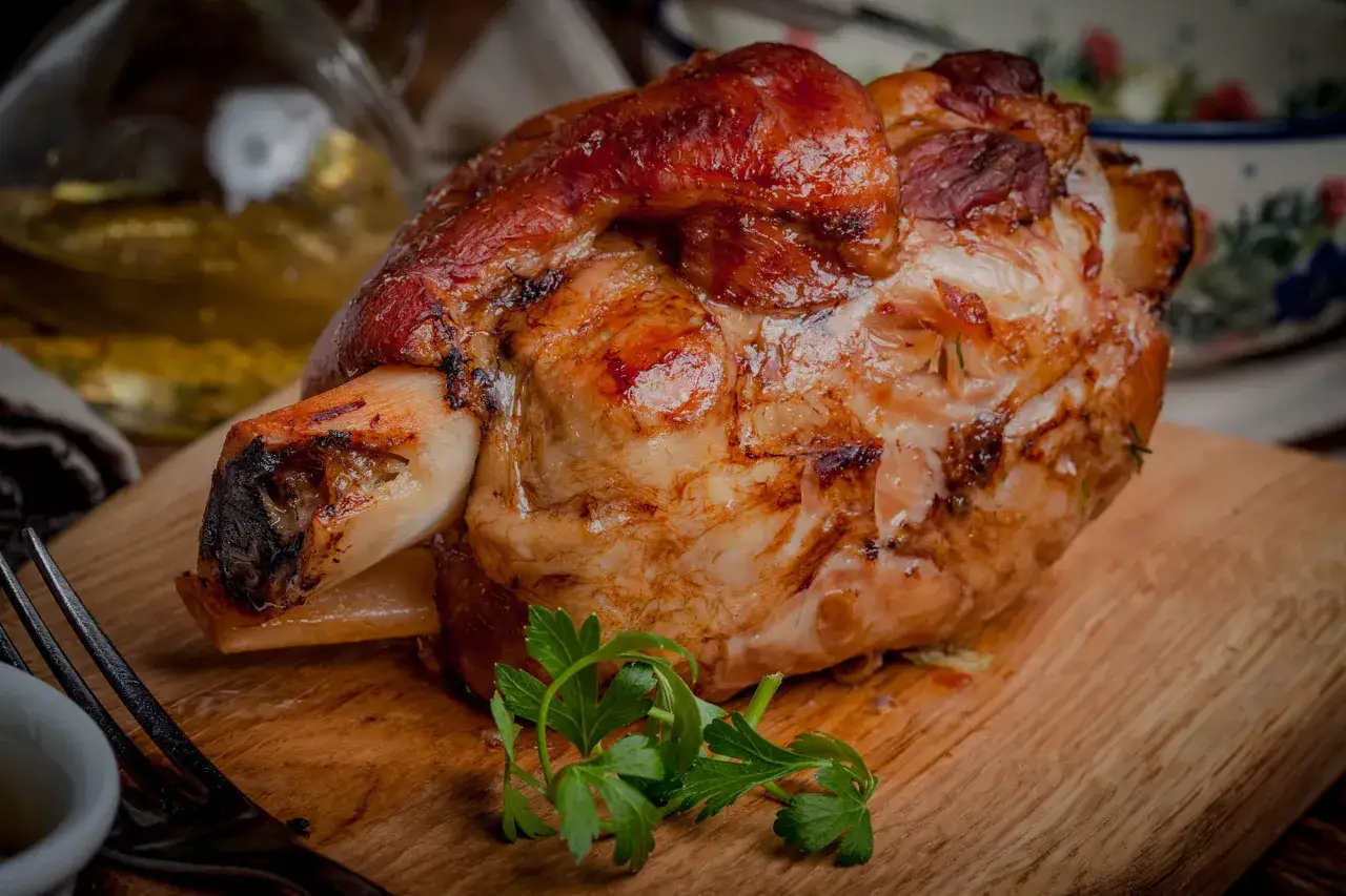 Stinco di maiale in pentola, dorato e succulento, pronto per essere gustato. Un piatto ricco e saporito.