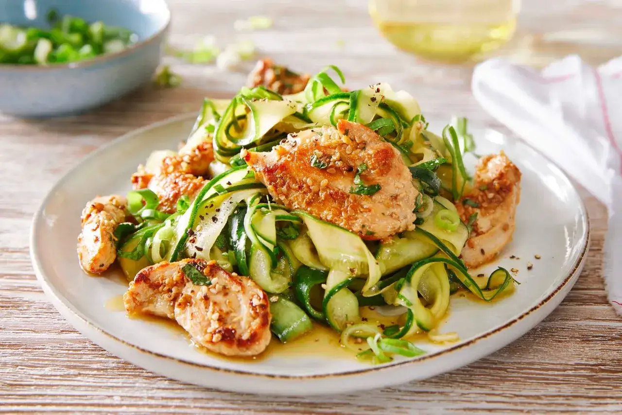 Gebratene H&auml;hnchenstreifen mit Gurken-Zoodles, ein leichtes sommer rezepte hauptgericht, garniert mit Fr&uuml;hlingszwiebeln und Sesam.