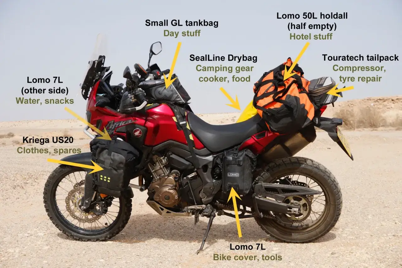 Czerwony motocykl turystyczny Honda Africa Twin z licznymi sakwami i bagażami, gotowy na wyprawę.