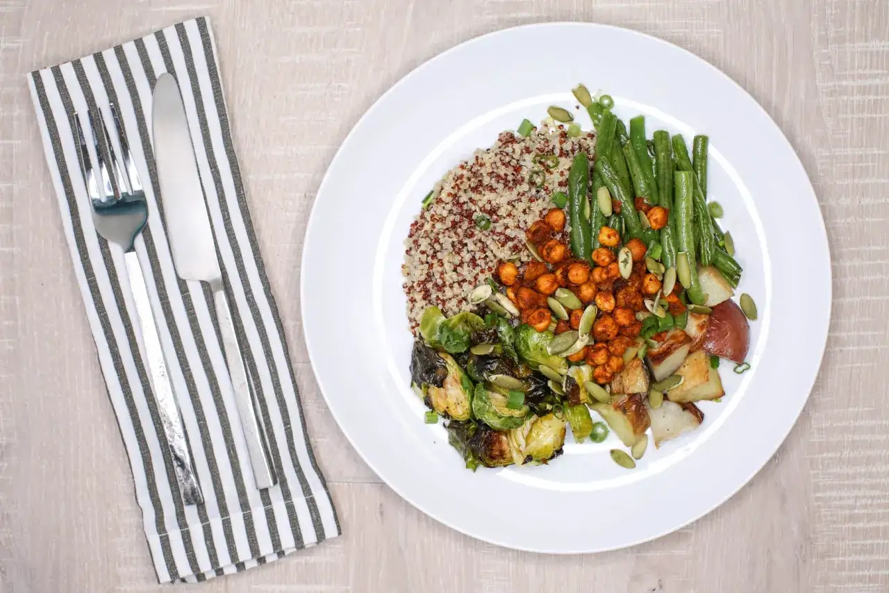Un plato con quinoa, jud&iacute;as verdes, garbanzos especiados, coles de Bruselas asadas y patatas. &iexcl;Una de las muchas deliciosas quinoa recetas!