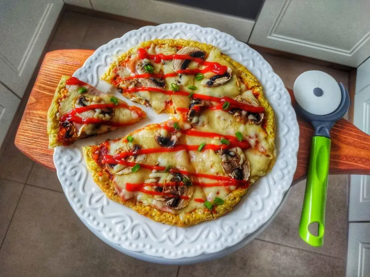 Pyszna pizza z serka wiejskiego z pieczarkami, serem i ketchupem, gotowa do pokrojenia.