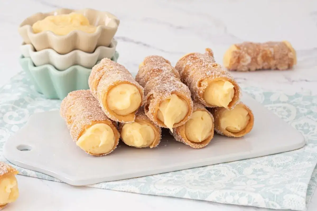 Deliciosos conos crujientes rellenos de crema pastelera hecha con Thermomix, espolvoreados con azúcar.