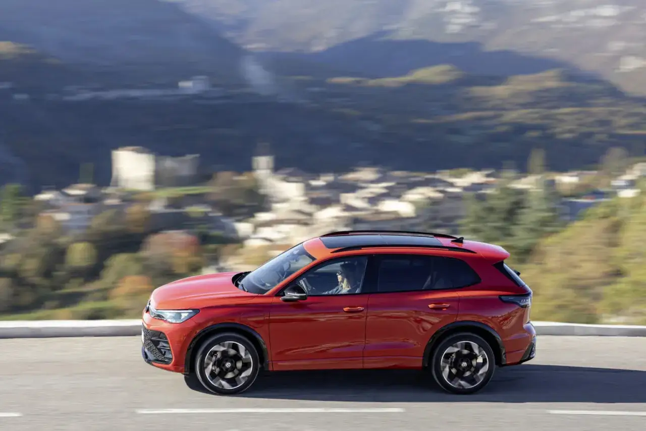 Czerwony SUV jedzie po krętej drodze, oferując swobodę podróżowania. Idealny wybór dla tych, którzy cenią elastyczność, jak w przypadku leasingu zwrotnego.