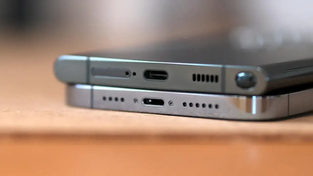 Dwa smartfony, jeden na drugim. G&oacute;rny ma port USB-C i głośnik, dolny port Lightning. Oba zasilane przez wydajny chip a16 bionic.